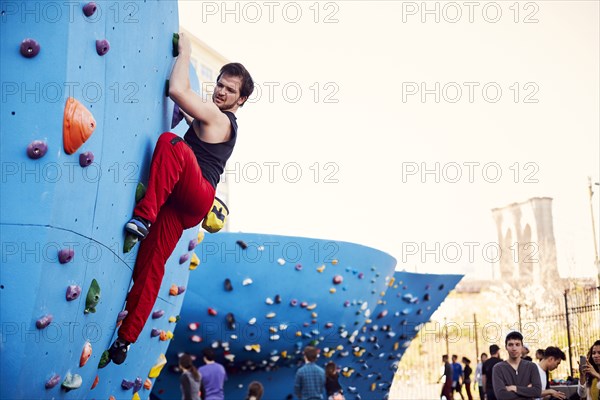 Caucasian man climbing outdoor climbing wall