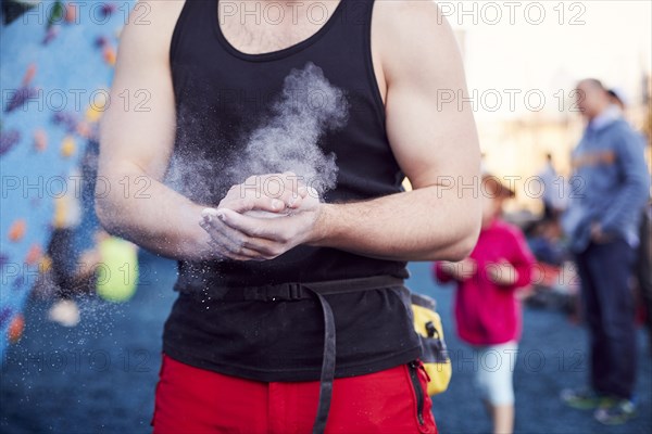 Caucasian man chalking hands at outdoor climbing wall