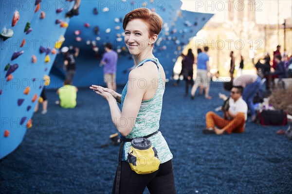 Caucasian woman smiling at outdoor climbing wall