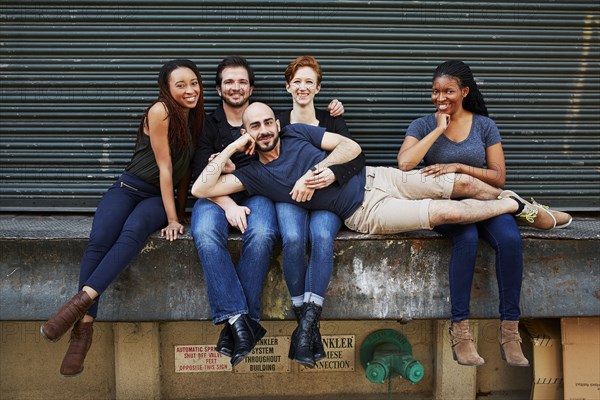 Man laying in laps of friends on loading dock