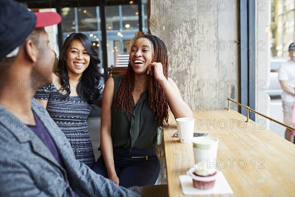 Friends laughing in coffee shop