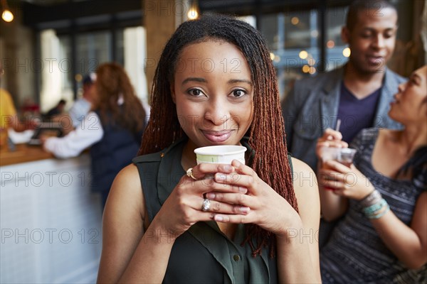 Smiling woman drinking coffee in cafe