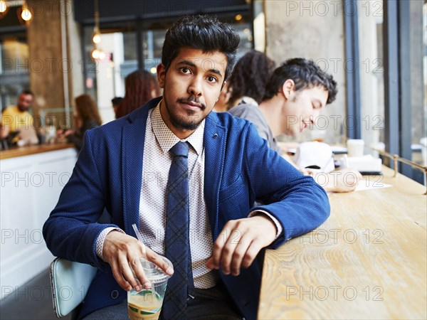 Man drinking cold beverage in cafe