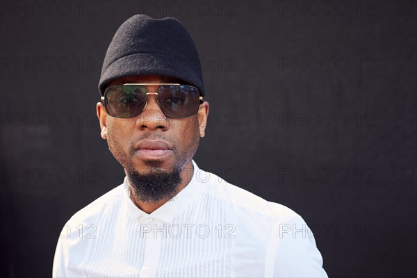 Serious African American man wearing sunglasses and hat