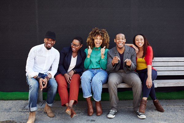 Laughing friends posing on bench