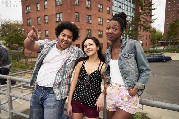 Curious friends leaning on city railing