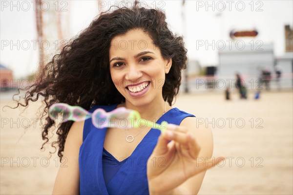 Woman holding bubble wand on beach