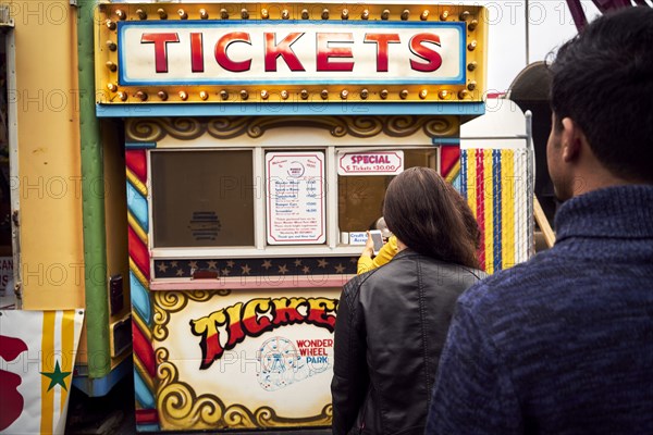 Friends waiting in line at amusement park ticket booth