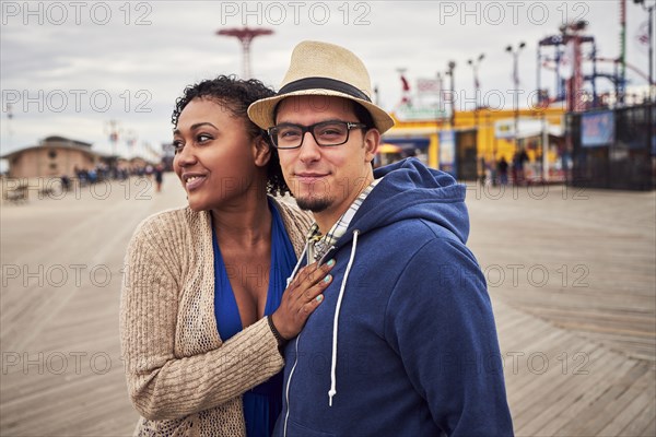 Couple standing on boardwalk at amusement park