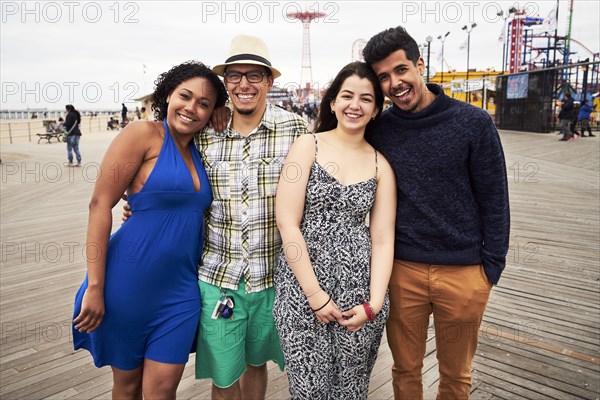 Friends posing on boardwalk at amusement park