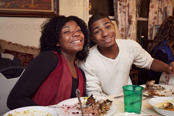 Smiling Black brother and sister at dinner table