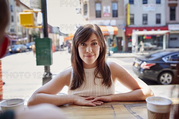 Smiling Caucasian woman leaning on counter in city