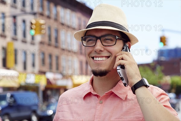 Hispanic man talking on cell phone in city