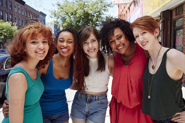 Friends smiling on city sidewalk