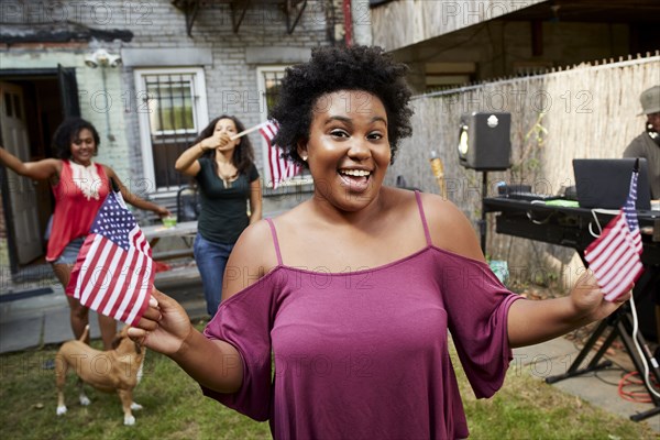 Women celebrating with American flags in backyard