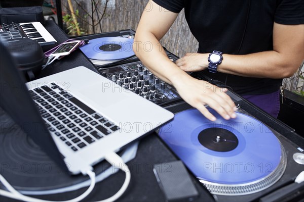 Hispanic dj playing music in backyard