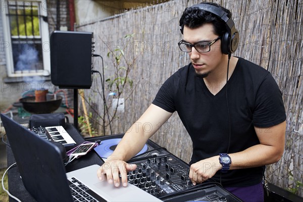 Hispanic dj playing music in backyard