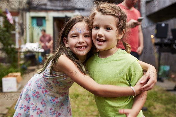 Caucasian girls hugging at backyard party