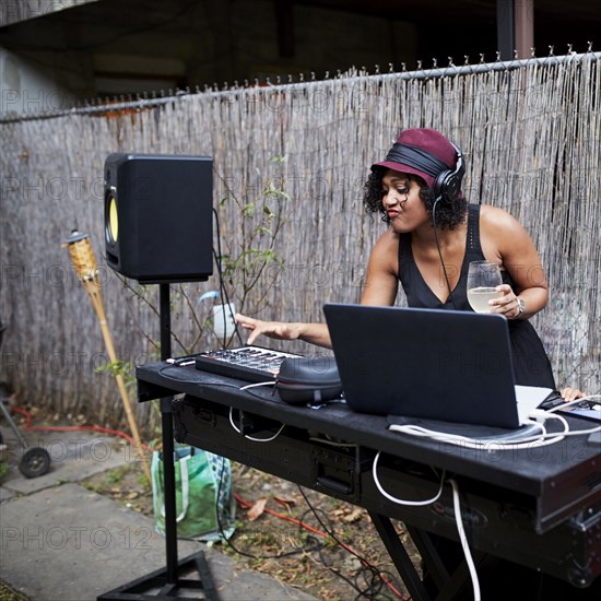 Mixed Race dj playing music in backyard