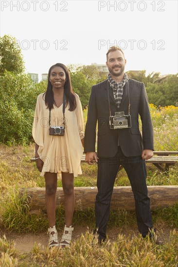 Couple with cameras holding hands