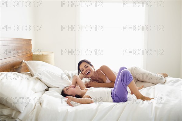 Mother and daughter laying in bed