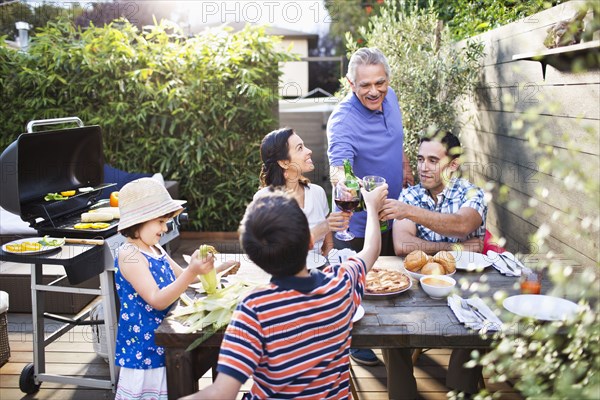 Family toasting each other at table outdoors