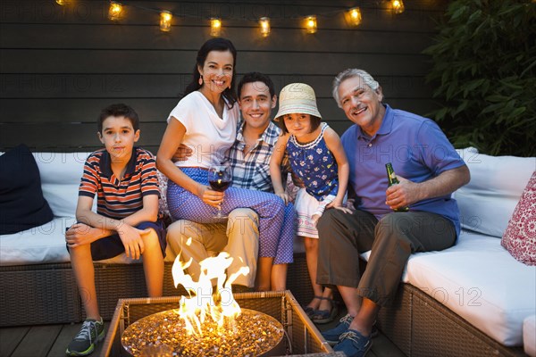 Family smiling around fire pit outdoors