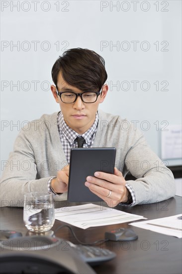 Korean businessman using digital tablet in office