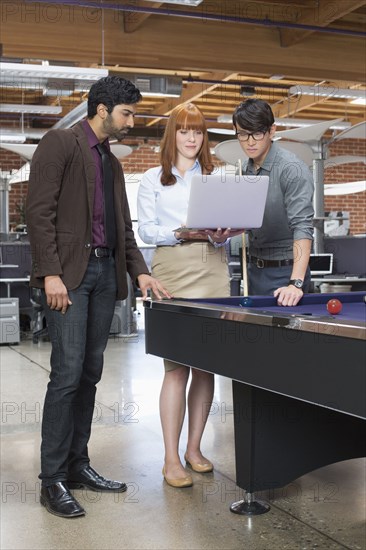 Business people using laptop in office lounge area