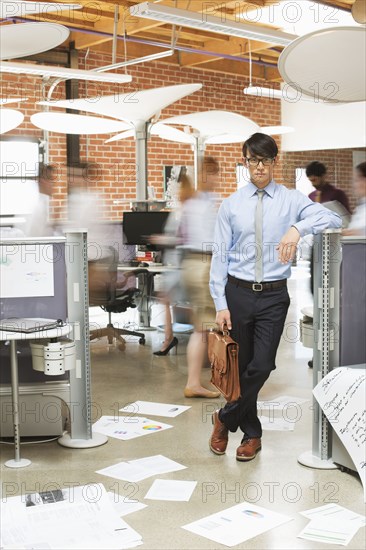 Businessman standing in busy office