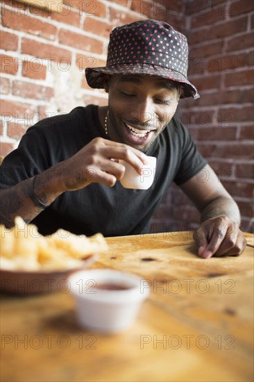 African American man having drink in restaurant
