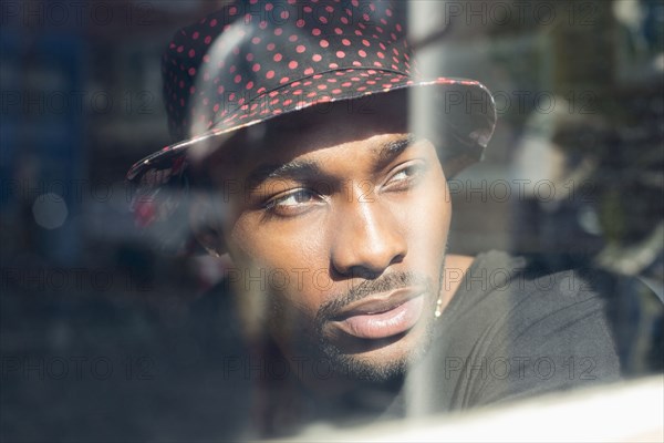 African American man looking out window