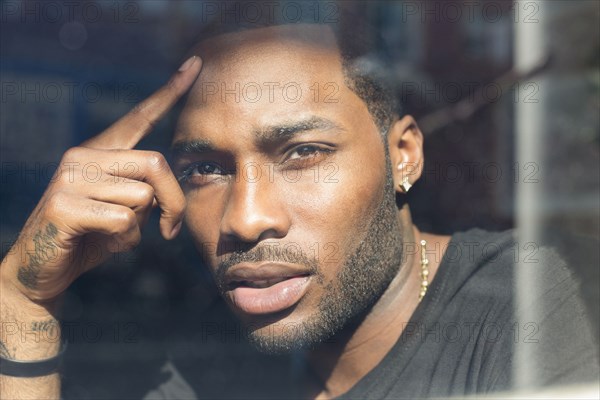 African American man looking out window