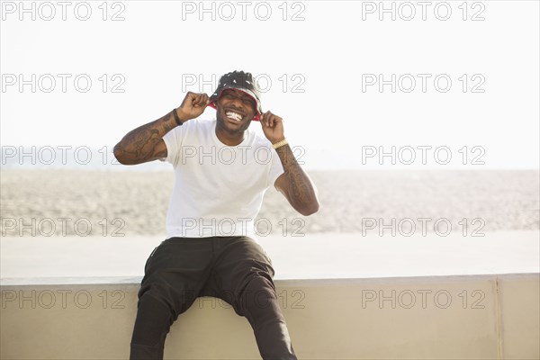 African American man smiling on beach wall