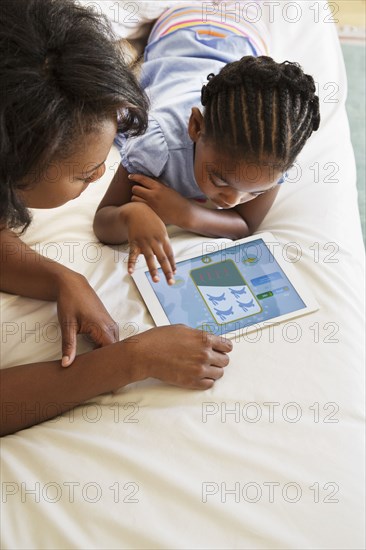 African American mother and daughter using digital tablet