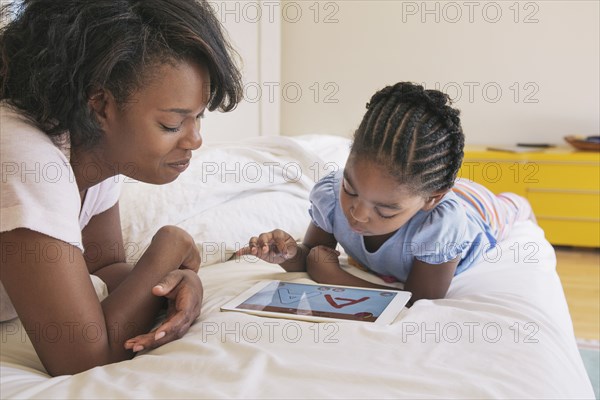 African American mother and daughter using digital tablet