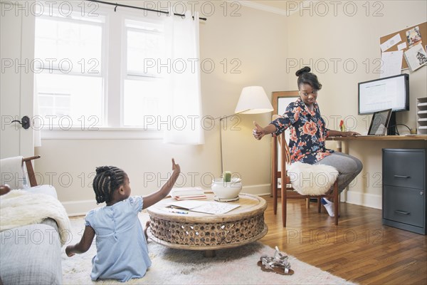 African American mother and daughter gesturing thumbs up