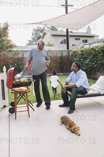 African American father and son talking at barbecue