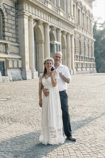 Caucasian newlywed couple hugging outdoors