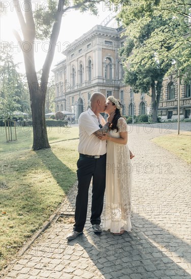 Caucasian newlywed couple kissing outdoors