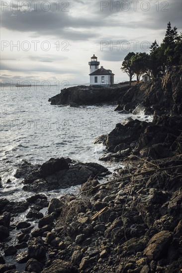 Distant lighthouse on rocky beach