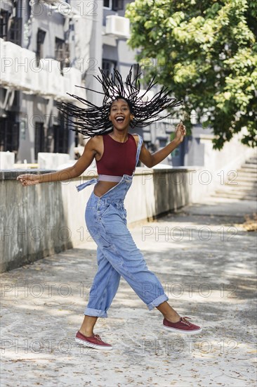 Carefree Mixed Race woman twirling hair outdoors