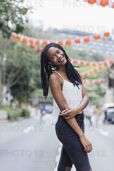 Portrait of smiling Mixed Race woman standing in street