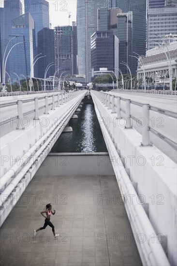 Mixed Race woman running under urban bridge