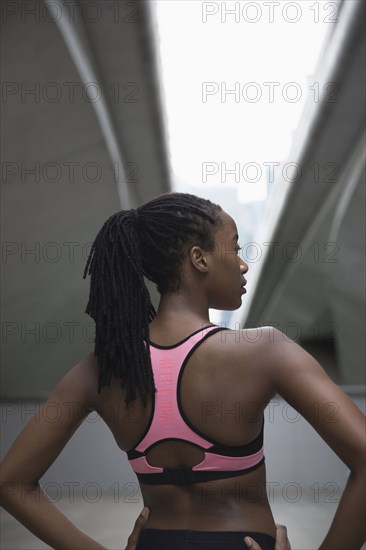 Mixed Race woman running standing under urban bridge