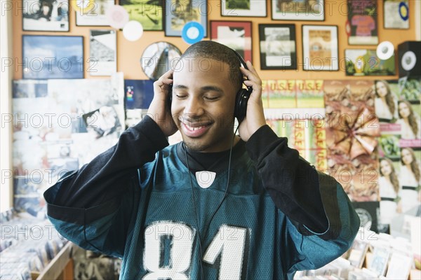 Teenage boy listening to headphones in a music store