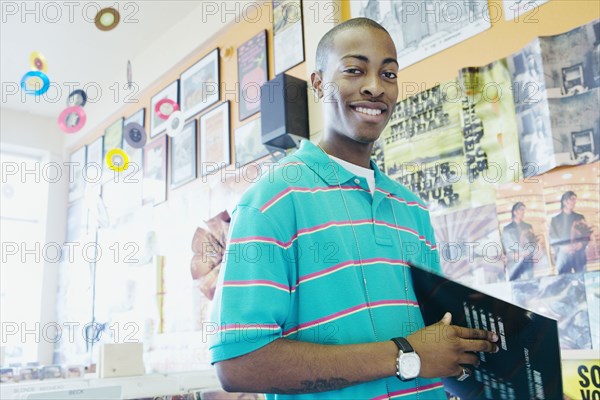 Teenage boy holding vinyl in a music store