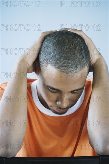 Young man holding his head in his hands