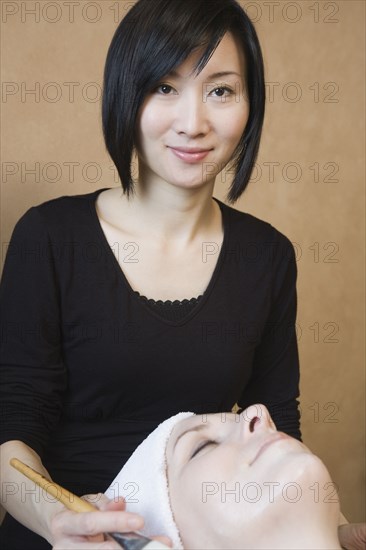 Asian woman performing spa treatment