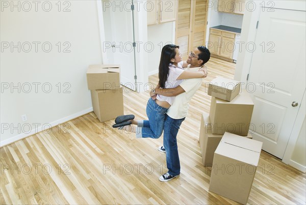 Asian couple hugging in new house